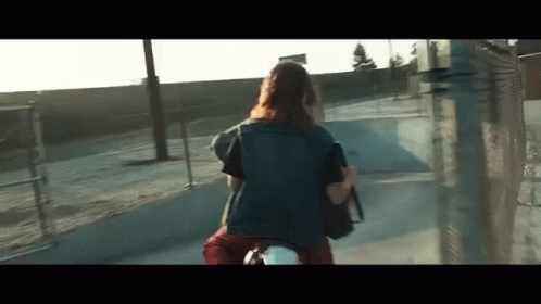 A Woman Is Riding A Motorcycle Down A Street With A Backpack . GIF