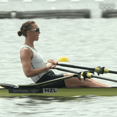 A Woman Is Rowing A Boat With The Letters Nzl On The Side GIF