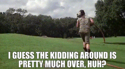 A Woman Is Running Through A Grassy Field With A Hula Hoop In Her Hand . GIF