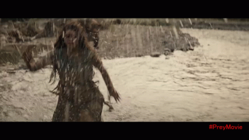 A Woman Is Running Through A River With #Preymovie On The Bottom Of The Screen GIF