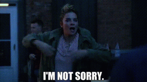 A Woman Is Saying I 'M Not Sorry While Standing In Front Of A Building . GIF