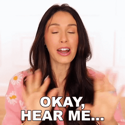 A Woman Is Saying Okay Hear Me With Her Hands In The Air GIF