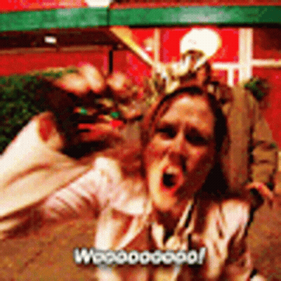 A Woman Is Screaming In Front Of A Group Of People And The Words Woooogood Are On The Bottom Right GIF