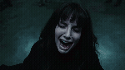 A Woman Is Screaming In The Dark With Her Mouth Wide Open GIF