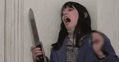 A Woman Is Screaming While Holding A Large Knife In Her Hand . GIF