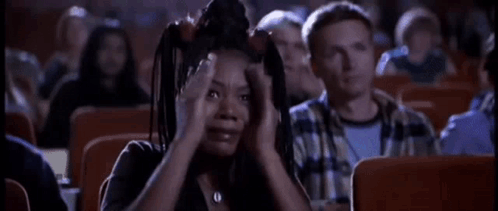 A Woman Is Screaming While Sitting In A Theater . GIF