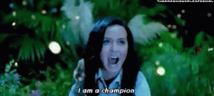A Woman Is Singing I Am A Champion In Front Of A Green Background . GIF
