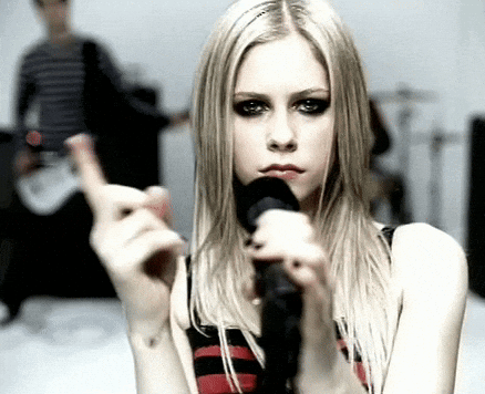 A Woman Is Singing Into A Microphone And Making A Funny Face GIF