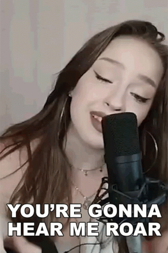 A Woman Is Singing Into A Microphone And Saying You 'Re Gonna Hear Me Roar . GIF