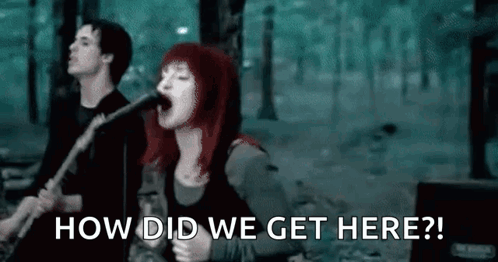 A Woman Is Singing Into A Microphone While A Man Plays A Guitar In A Band . GIF