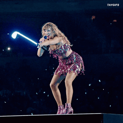 A Woman Is Singing Into A Microphone While Holding A Light Stick GIF