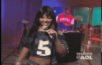 A Woman Is Singing Into A Microphone While Wearing A Number 5 Shirt GIF