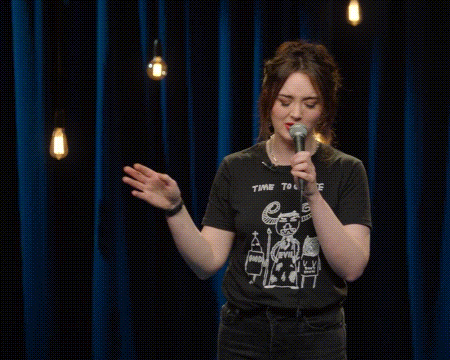 A Woman Is Singing Into A Microphone While Wearing A T-Shirt That Says Choose . GIF