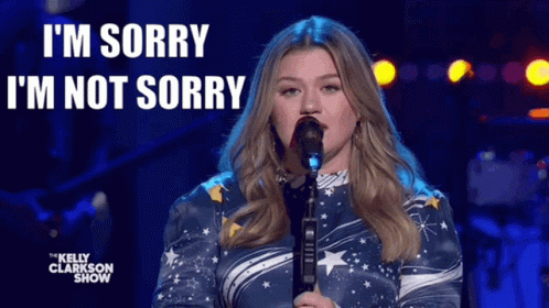 A Woman Is Singing Into A Microphone With The Words I 'M Sorry I 'M Not Sorry Behind Her GIF