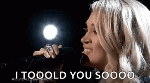 A Woman Is Singing Into A Microphone With The Words `` I Tooold You Soooo '' . GIF