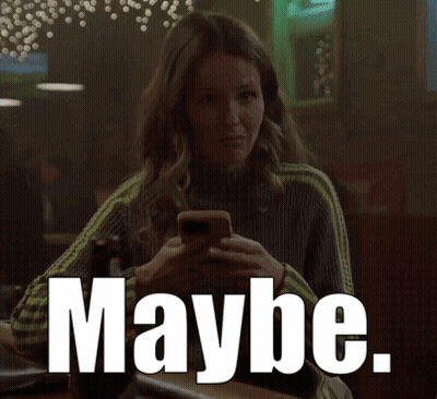 A Woman Is Sitting At A Bar Looking At Her Phone And The Word Maybe Is Visible GIF