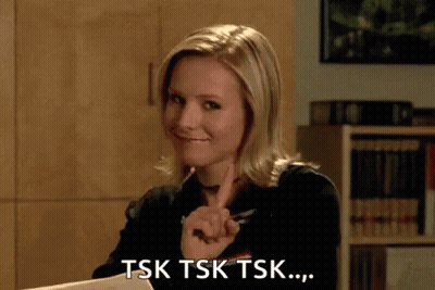 A Woman Is Sitting At A Desk And Pointing At Something . GIF
