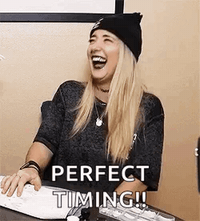 A Woman Is Sitting At A Desk Laughing While Using A Computer Keyboard . GIF