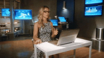 A Woman Is Sitting At A Desk Using A Laptop Computer GIF