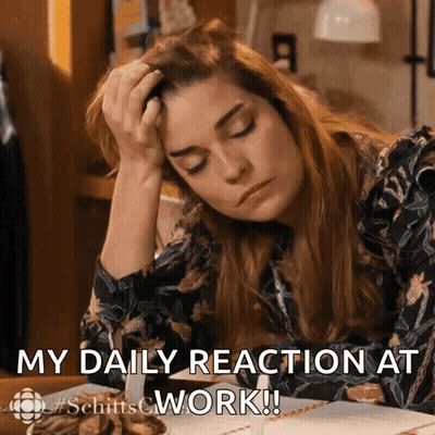 A Woman Is Sitting At A Desk With Her Head In Her Hand And The Words " My Daily Reaction At Work " Below Her GIF