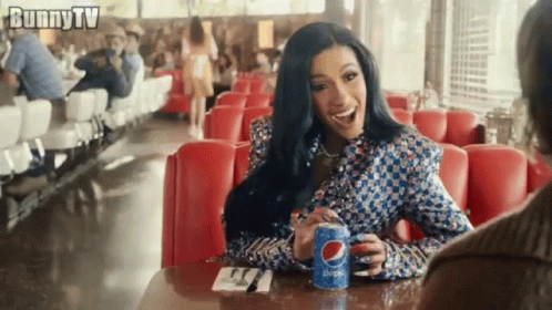 A Woman Is Sitting At A Diner Table Holding A Can Of Pepsi . GIF