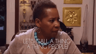 A Woman Is Sitting At A Table And Saying Let 'S Call A Thing A Thing People GIF