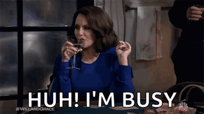 A Woman Is Sitting At A Table Drinking A Glass Of Wine And Saying I 'M Busy . GIF