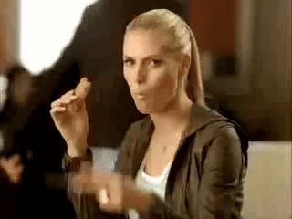 A Woman Is Sitting At A Table Eating A Chicken Nugget . GIF