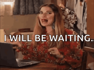 A Woman Is Sitting At A Table In Front Of A Laptop Computer And Saying `` I Will Be Waiting '' . GIF