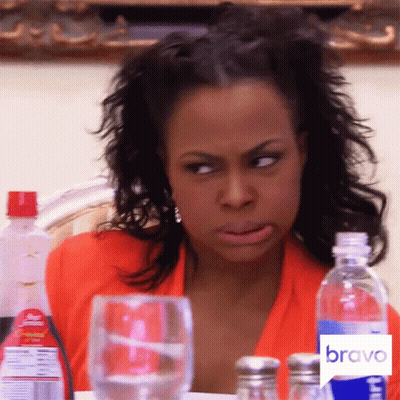 A Woman Is Sitting At A Table With A Bravo Logo On The Bottom GIF