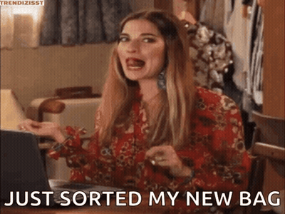 A Woman Is Sitting At A Table With A Laptop And Saying `` Just Sorted My New Bag '' GIF