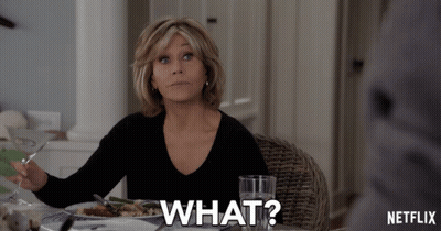 A Woman Is Sitting At A Table With A Plate Of Food And A Glass Of Water And Says What GIF