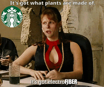 A Woman Is Sitting At A Table With A Starbucks Logo In The Background And Says It 'S Got What Plants Are Made Of GIF