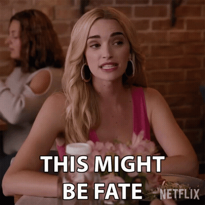 A Woman Is Sitting At A Table With Flowers And Says This Might Be Fate GIF