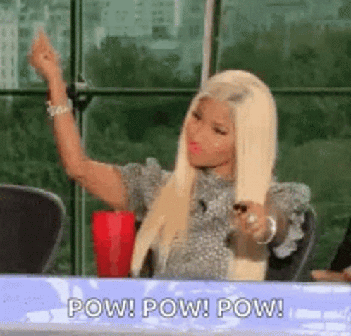 A Woman Is Sitting At A Table With Her Hands In The Air And A Cup Of Coffee . GIF
