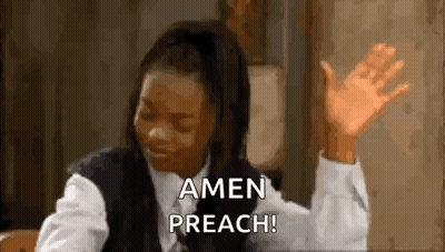 A Woman Is Sitting At A Table With Her Hands In The Air . GIF