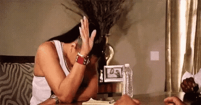 A Woman Is Sitting At A Table With Her Head In Her Hands . GIF