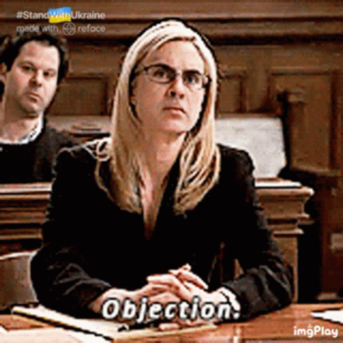 A Woman Is Sitting At A Table With The Word Objection On Her Hand GIF
