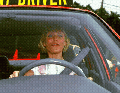 A Woman Is Sitting In A Car Under A Sign That Says " Taxi Driver " GIF