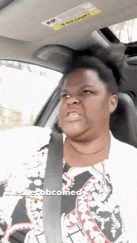 A Woman Is Sitting In A Car With A Sticker On The Roof That Says Warning GIF