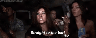 A Woman Is Sitting In A Car With Her Arms In The Air And A Group Of People . GIF