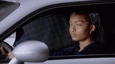 A Woman Is Sitting In A Car With Her Eyes Closed GIF