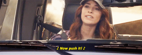 A Woman Is Sitting In A Car With The Words Now Push It On The Windshield GIF
