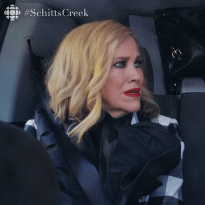 A Woman Is Sitting In A Car With The Words What Is It GIF