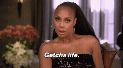 A Woman Is Sitting In A Chair And Saying Getcha Life GIF