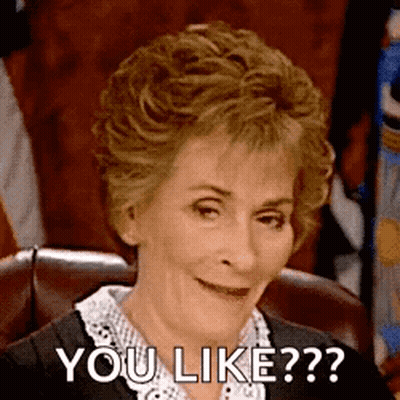 A Woman Is Sitting In A Chair And Smiling While Saying `` You Like ? '' . GIF