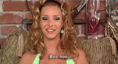 A Woman Is Sitting In A Chair And Smiling While Wearing A Green Top . GIF