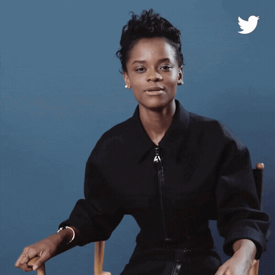A Woman Is Sitting In A Chair And The Word Wakanda Is On The Bottom GIF