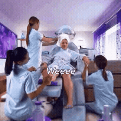 A Woman Is Sitting In A Chair Getting Her Hair Washed By A Group Of Women In A Salon . GIF