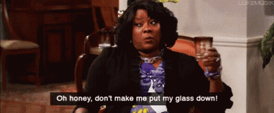 A Woman Is Sitting In A Chair Holding A Glass And Saying Oh Honey , Don 'T Make Me Put My Glass Down GIF